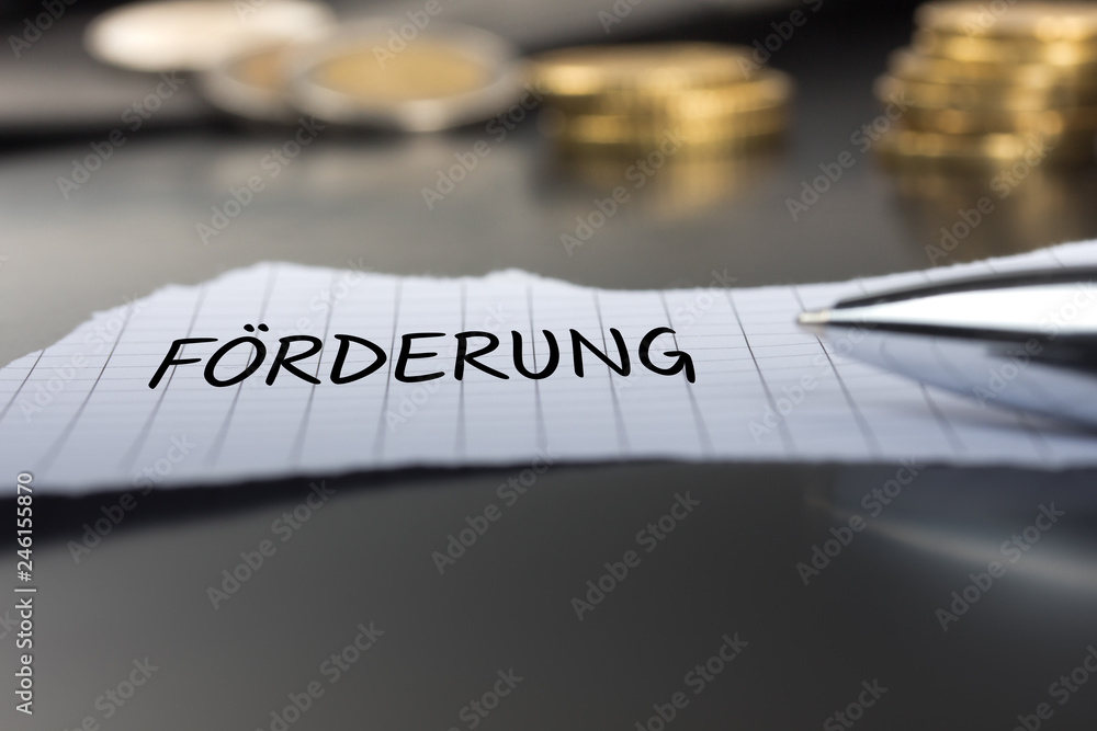 Förderung auf einem Zettel mit Stift vor Geldmünzen