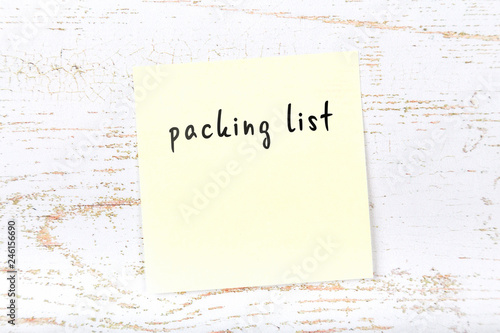 Yellow sticky note with handwritten text packing list photo