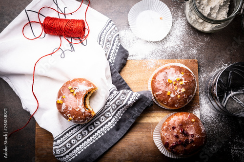 Pączki, karnawałowa uczta. Apetyczne słodkie ciastka na kuchennym stole.