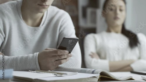 Man chatting with her phone and ignoring his girlfriend photo