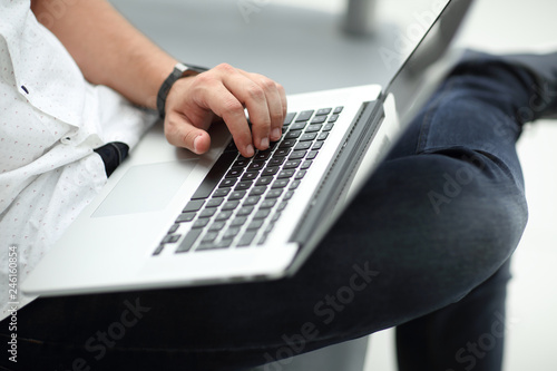 close up. businessman using laptop sitting on sofa