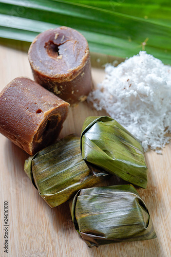 Koci the malay glutinous rice ball served in banana leaf on white plate over wooden table