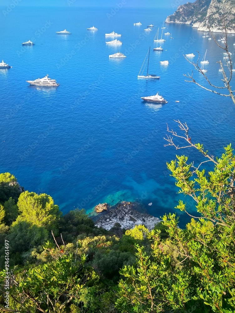Blue sea with yachts and sky and coast with green