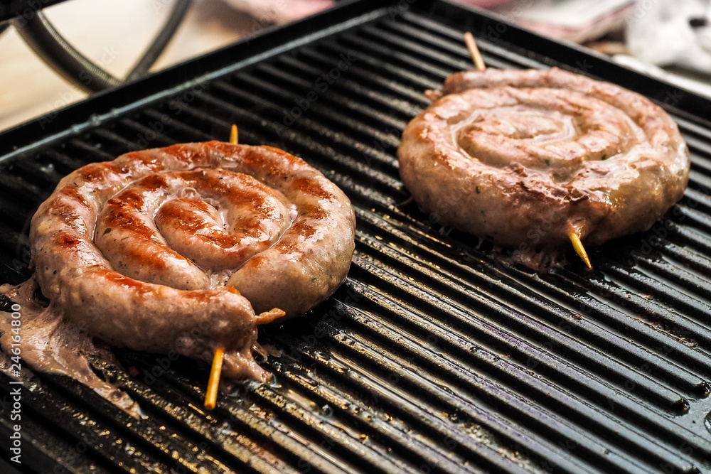 Fried spiral sausages on an electric barbecue BBQ grill. Homemade menu. Fried spiral sausages on an electric barbecue BBQ grill. Homemade menu.