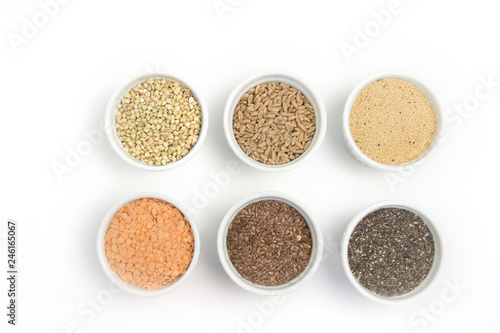 Collection of different groats on white background. Top view of buckwheat, chia, flax, amaranth, lentils, couscous, wheat