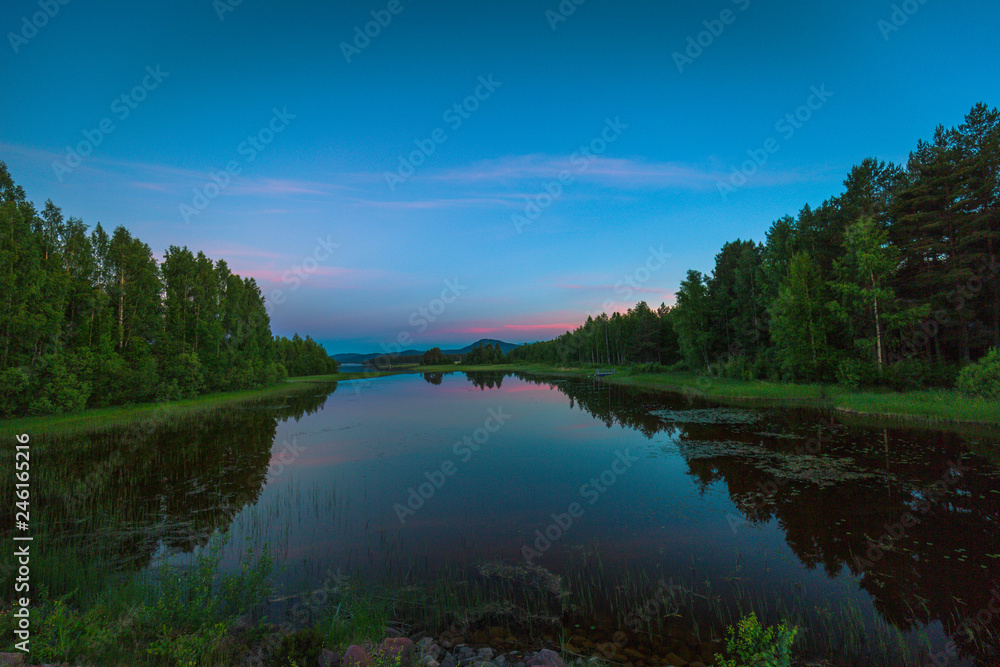 Nordic landscape, travel concept, Scandinavian summer landscape, green fields and blue sky in the evening. Mora, Sweden.