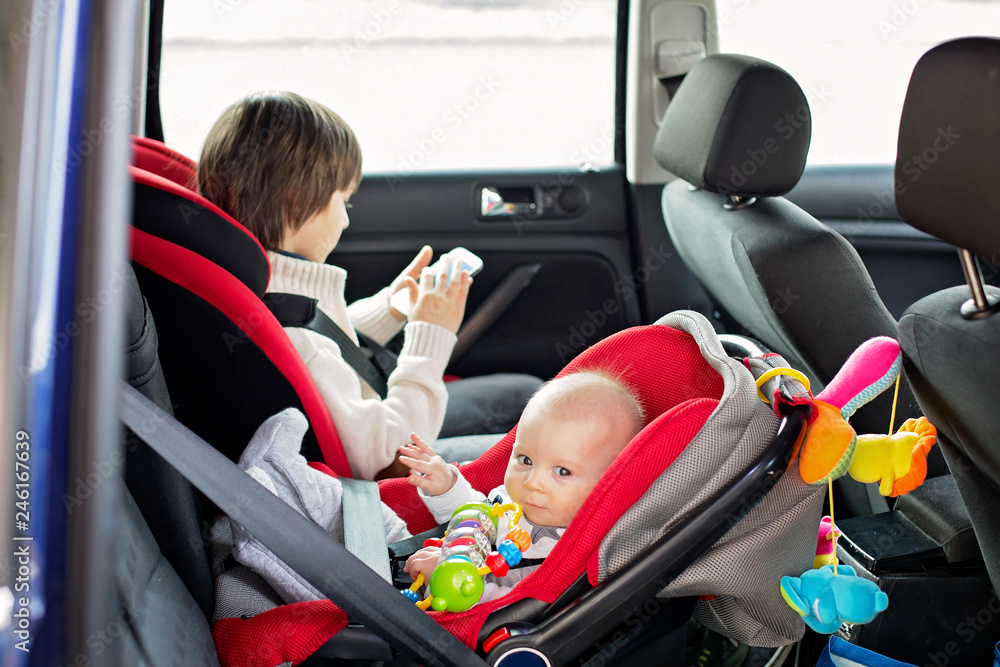 Little baby boy and his older brother, traveling in car seats, going on a holiday Little baby boy and his older brother, traveling in car seats, going on a holiday