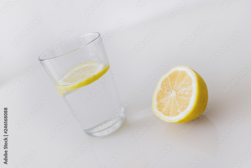 A glass of fresh cool water with lemon slices on a white background