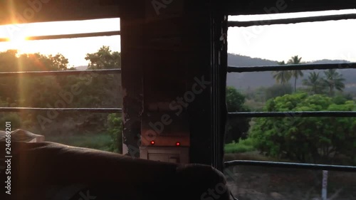 Sunset: passenger journey train rides view from train man a sleep in Indian Railways, Indian trains, sleeper class, the sun's rays hit train at sunset