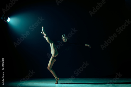 Young female ballet dancer dancing on neon lights studio background. Ballerina project with caucasian model. The ballet, dance, art, contemporary, choreography concept © master1305