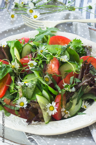 Bunter Wildkräutersalat mit essbaren Blüten auf einem Teller photo