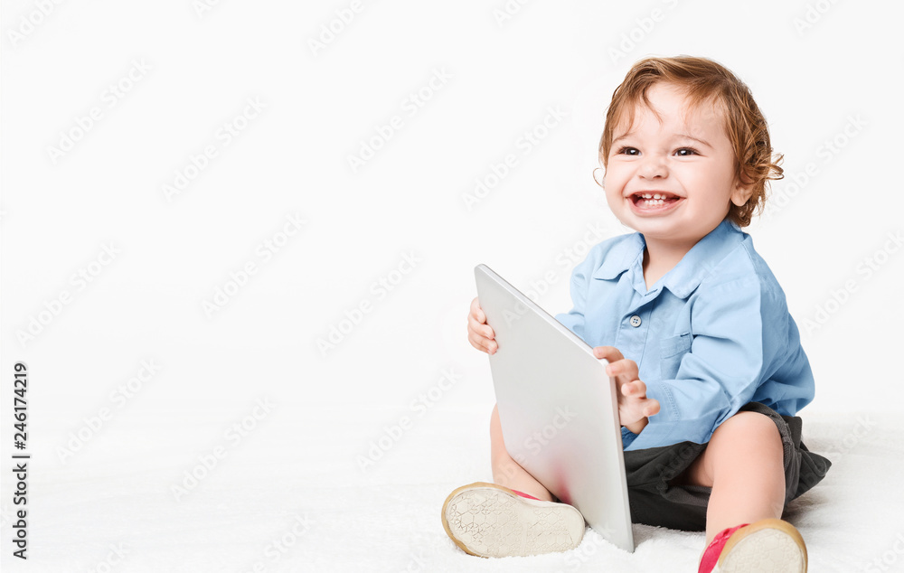 Baby boy holding tablet pc, studio background Baby boy holding tablet pc, studio background
