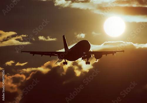 Takeoff of a passenger plane on the background of a sunset.