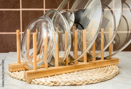 Obraz na płótnie Wooden natural color rack for holding pot/pan lids in kitchen