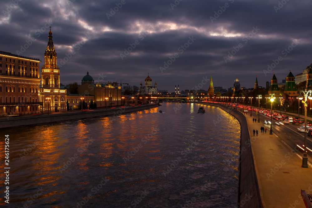Embankments of Moskva river against Moscow Kremlin on a background of cloudy sky at evening. City landscape