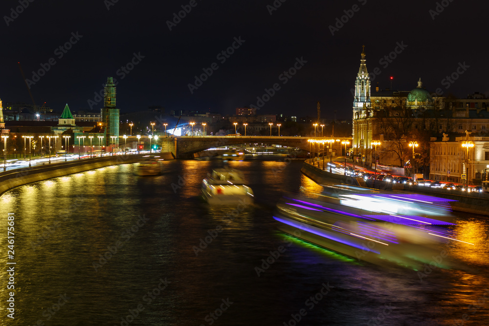 Glowing traces of pleasure boats on Moskva river at night. City landscape