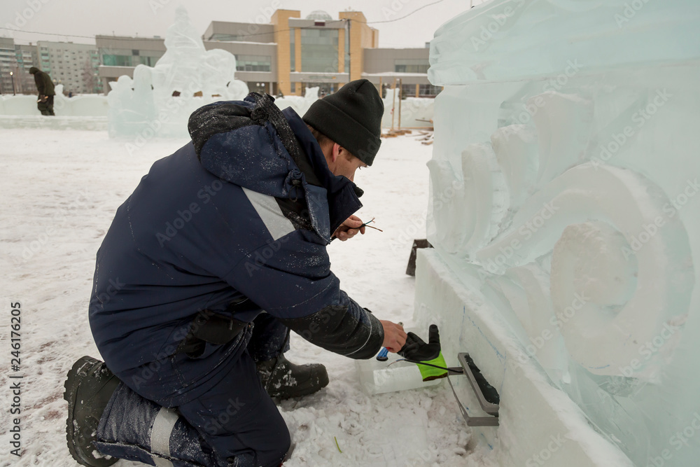 Worker sets the spotlight in the ice figure Worker sets the spotlight in the ice figure