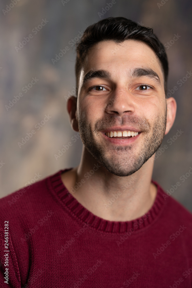 Obraz premium Handsome caucasian white male with black short hair and stubble and burgundy sweater jersey smiling