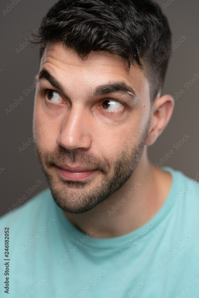 Handsome caucasian white male with black short hair and stubble with light blue t shirt Handsome caucasian white male with black short hair and stubble with light blue t shirt