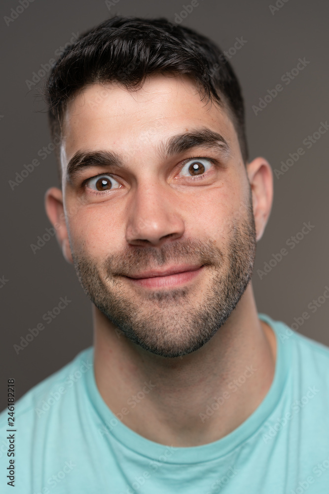 Handsome caucasian white male with black short hair and stubble with light blue t shirt Handsome caucasian white male with black short hair and stubble with light blue t shirt