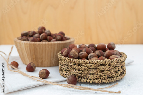 Hazelnuts in a wooden bowl and wicker basket. Composition of nuts.