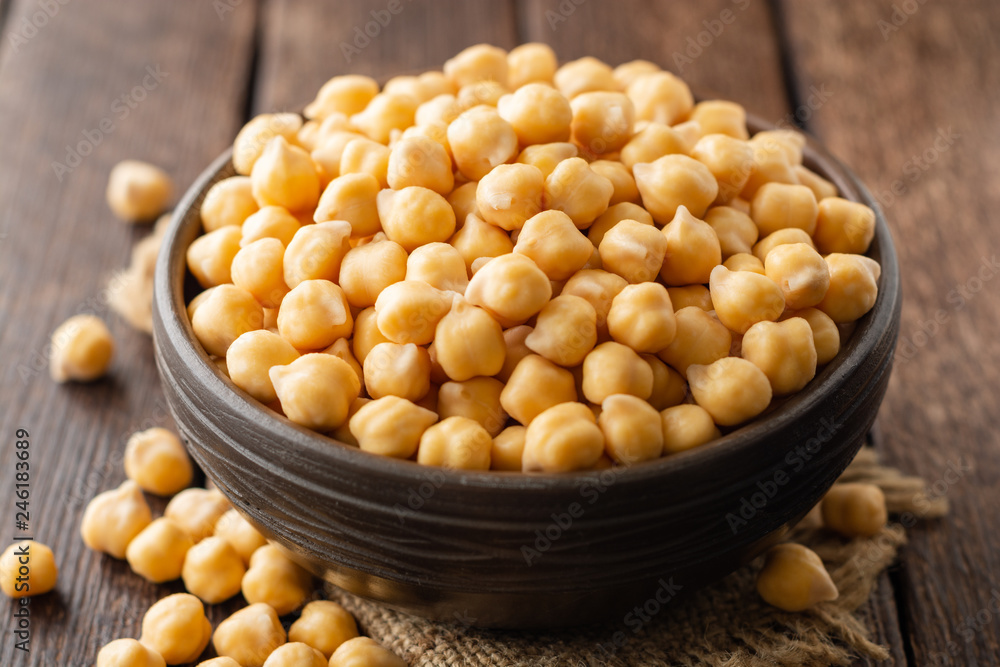 Chickpeas in ceramic bowl on dark wooden rustic table. Selective focus. Chickpeas in ceramic bowl on dark wooden rustic table. Selective focus.