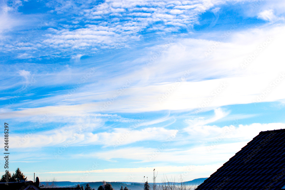 blue sky background with clouds in front of houses