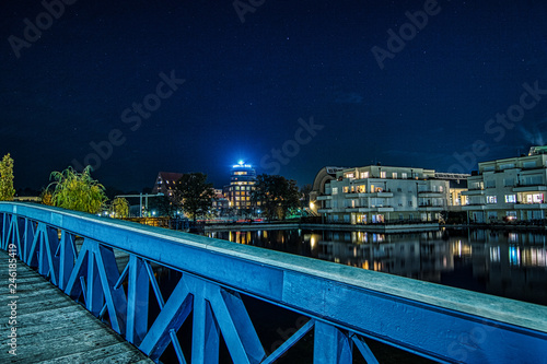 Nachtaufnahme blaue Brücke und Wohnhäuser im Humboldthafen in Berlin Tegel photo