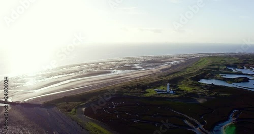 Drone footage over lighthouse, with windfarm in background. Walney Island. Cumbria UK.