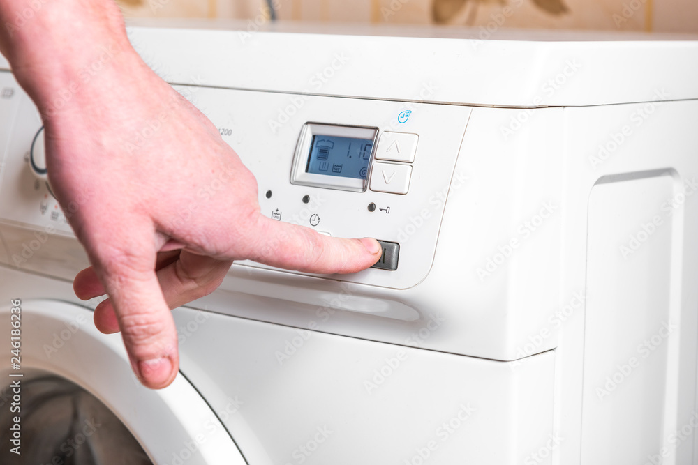 Woman select the program on washing machine. Laundry day at home. Woman select the program on washing machine. Laundry day at home.