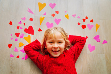 happy cute little girl play with hearts from paper, valentine day