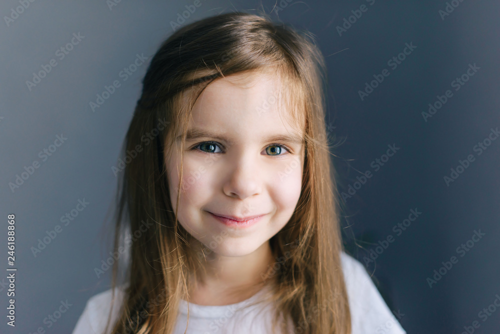 Portrait of beautiful happy girl in white t-shirt isolated on grey background. Portrait of beautiful happy girl in white t-shirt isolated on grey background.