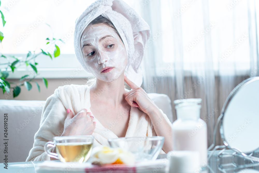 Beautiful happy woman with cosmetic natural mask on her face looking at her skin. Skin care and Spa treatments Beautiful happy woman with cosmetic natural mask on her face looking at her skin. Skin care and Spa treatments