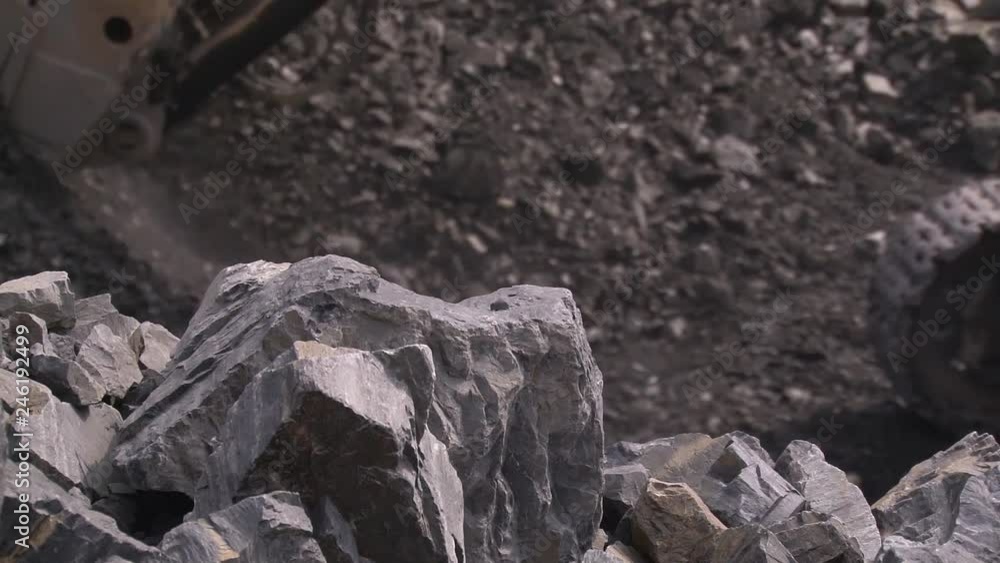 Excavator loads rock into a huge truck Excavator loads rock into a huge truck