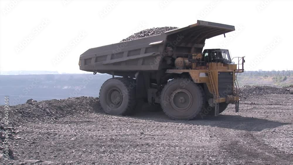 Huge trucks drive through an iron ore quarry Huge trucks drive through an iron ore quarry