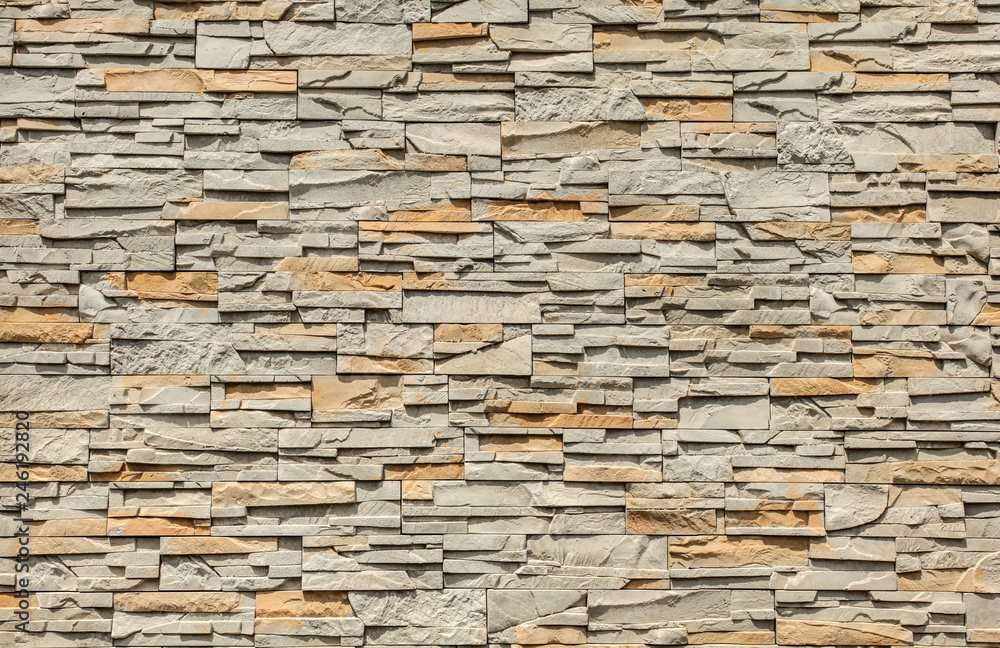 Tiled stone wall made of rectangular blocks, sun shining from top. Tiled stone wall made of rectangular blocks, sun shining from top.