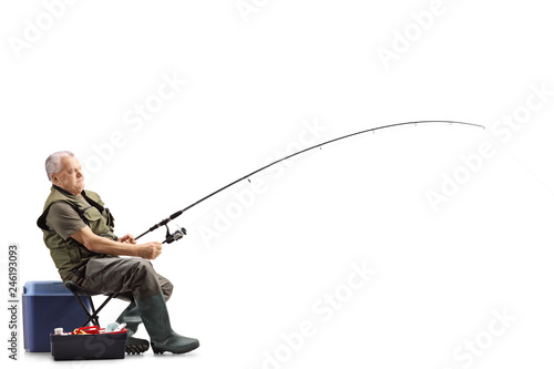 Fisherman on a chair with a fishing rod waiting for a catch photo