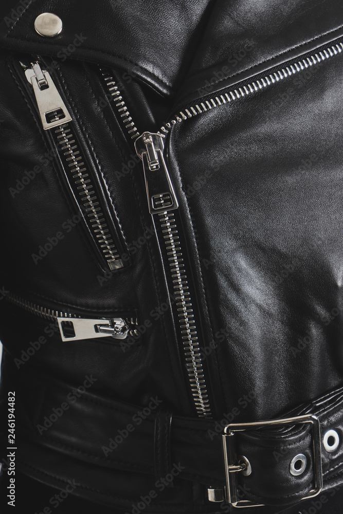 Black leather jackets with metallic zipper and buttons. Classic clothes for biker. Detailed vertical closeup view. Black leather jackets with metallic zipper and buttons. Classic clothes for biker. Detailed vertical closeup view.