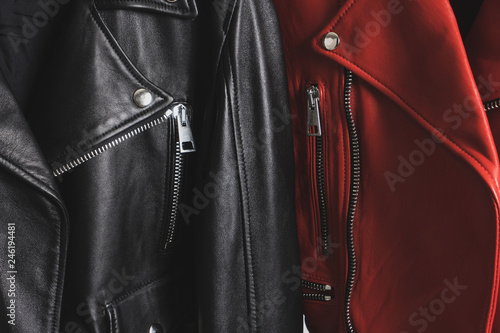 Red and black leather jackets with metallic zipper and buttons. Man and woman concept. Detailed closeup view.