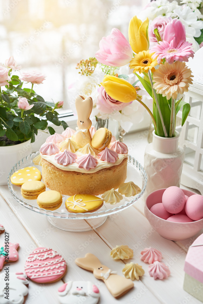 Easter composition with sweet bread, Easter cake, eggs, bouquet of flowers. Holidays breakfast concept with copy space. Traditional easter cake with gingerbread cookies. Easter Greeting Card Template Easter composition with sweet bread, Easter cake, eggs, bouquet of flowers. Holidays breakfast concept with copy space. Traditional easter cake with gingerbread cookies. Easter Greeting Card Template
