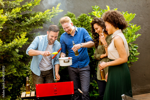 Happy friends grilling food...