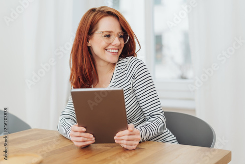 Happy natural young woman holding a tablet