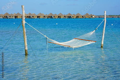 Hammock with a view, planted in the azure waters of the Bora Bora lagoon, French Polynesia