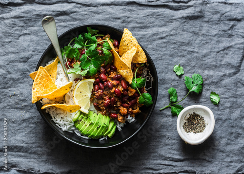 Photos Burrito rice bowl with tortilla chips, cilantro and avocado on grey background,