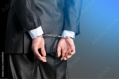 Cropped image of male hands in handcuffs behind his back