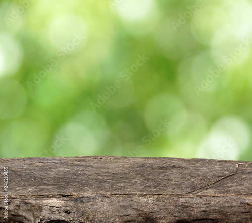 Empty wooden table. Blurred green background. Place for the presentation of your products.