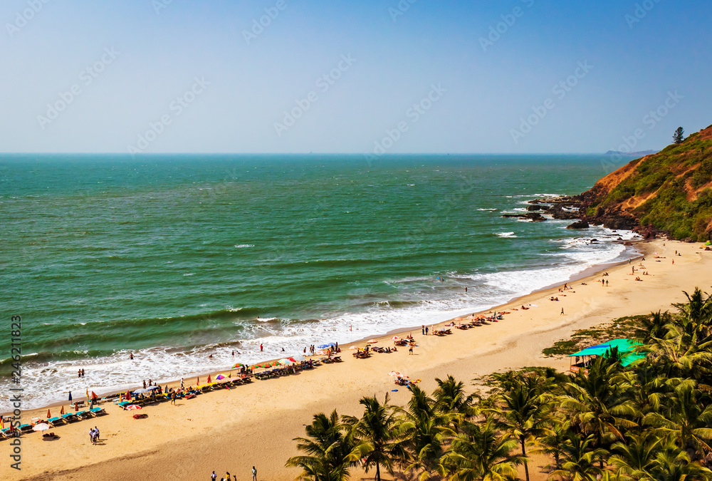 top view of beach in Goa India vagator beach. people taking sunbath on the beach on shacks 