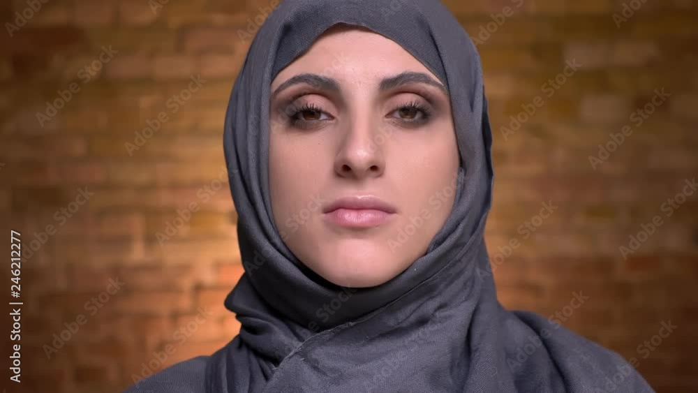 Portrait of female hands doing eye make-up using brown pensil for muslim woman in hijab on bricken wall background. Portrait of female hands doing eye make-up using brown pensil for muslim woman in hijab on bricken wall background.