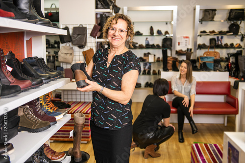 A sale, shopping and people concept happy young woman or shop assistant at store photo