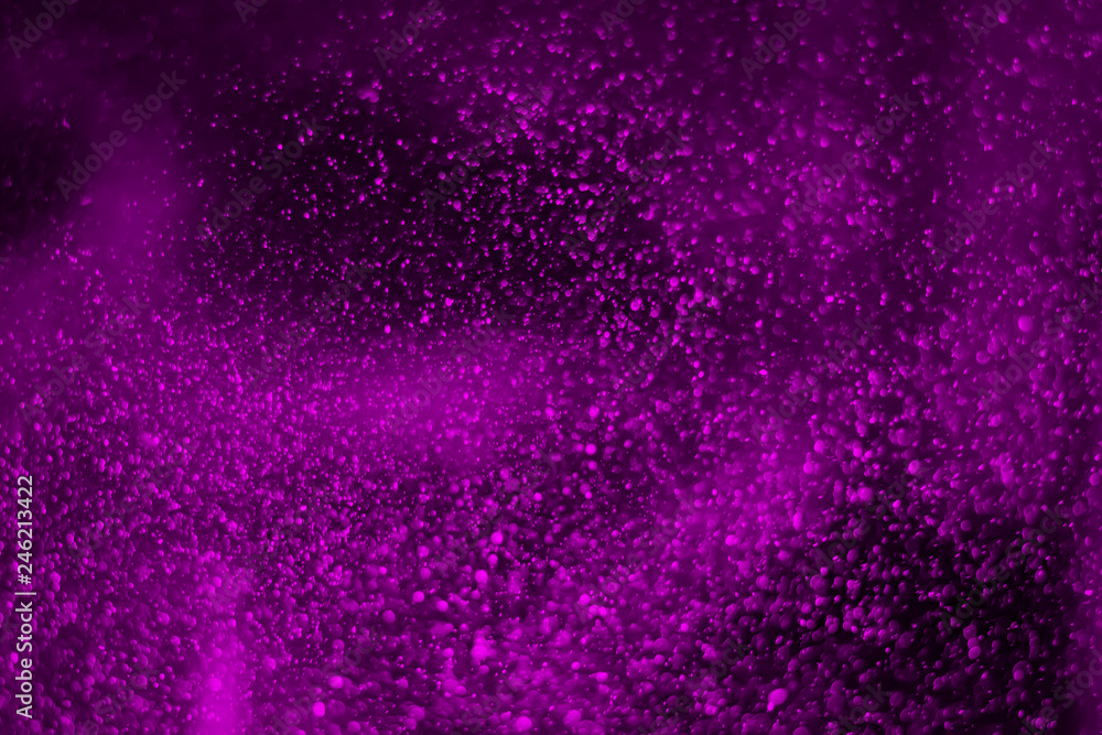 Abstract real purple dust floating over black background.Dust paricles for overlay use in grunge design. Blurred dust concept.